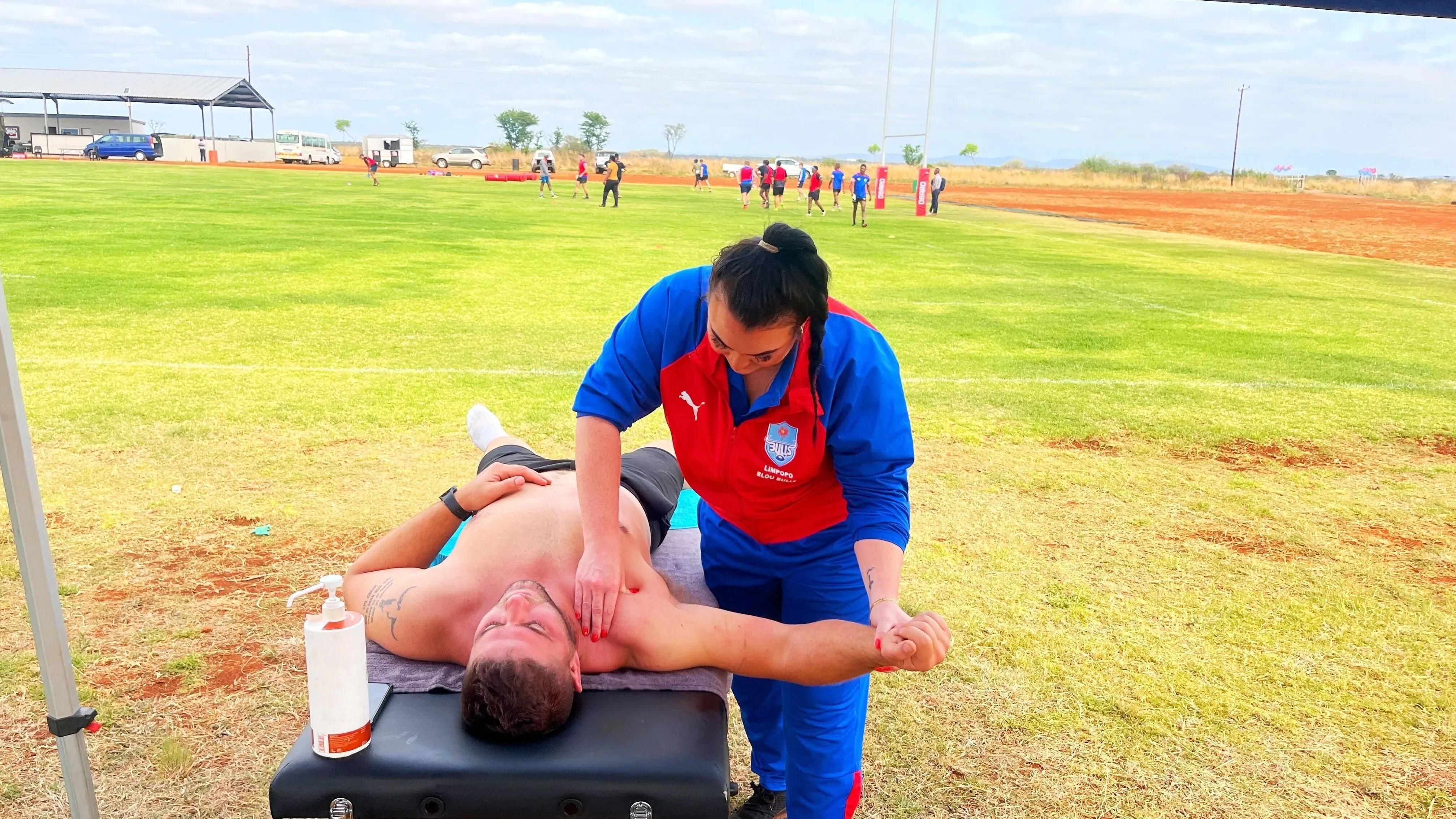 Yvonne treating a player's shoulder on the side of the field